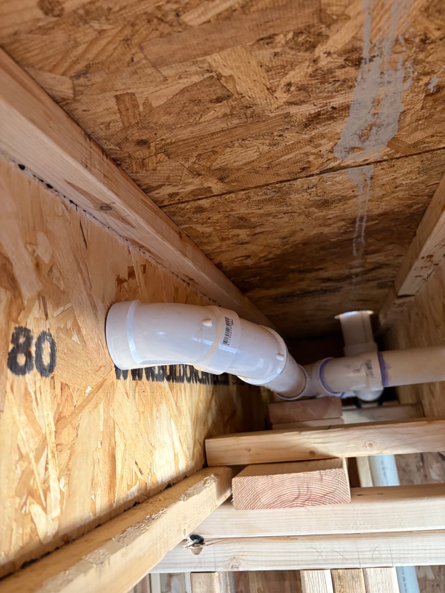 PVC drain pipe routed through wood floor joists during new construction in Hanover, MD — ProStream Plumbing