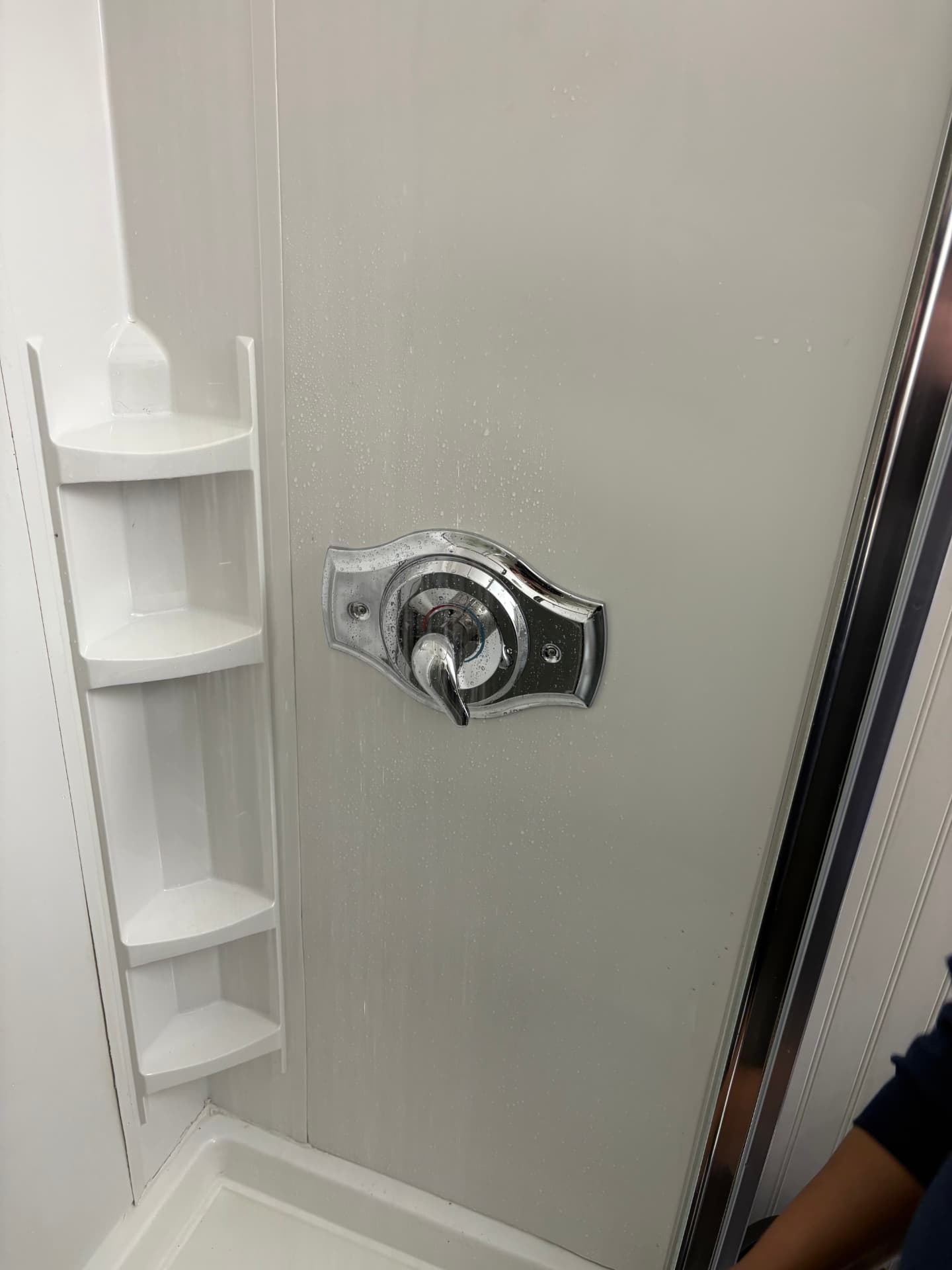 Finished chrome shower handle and escutcheon plate in a white shower stall in Baltimore, MD — ProStream Plumbing