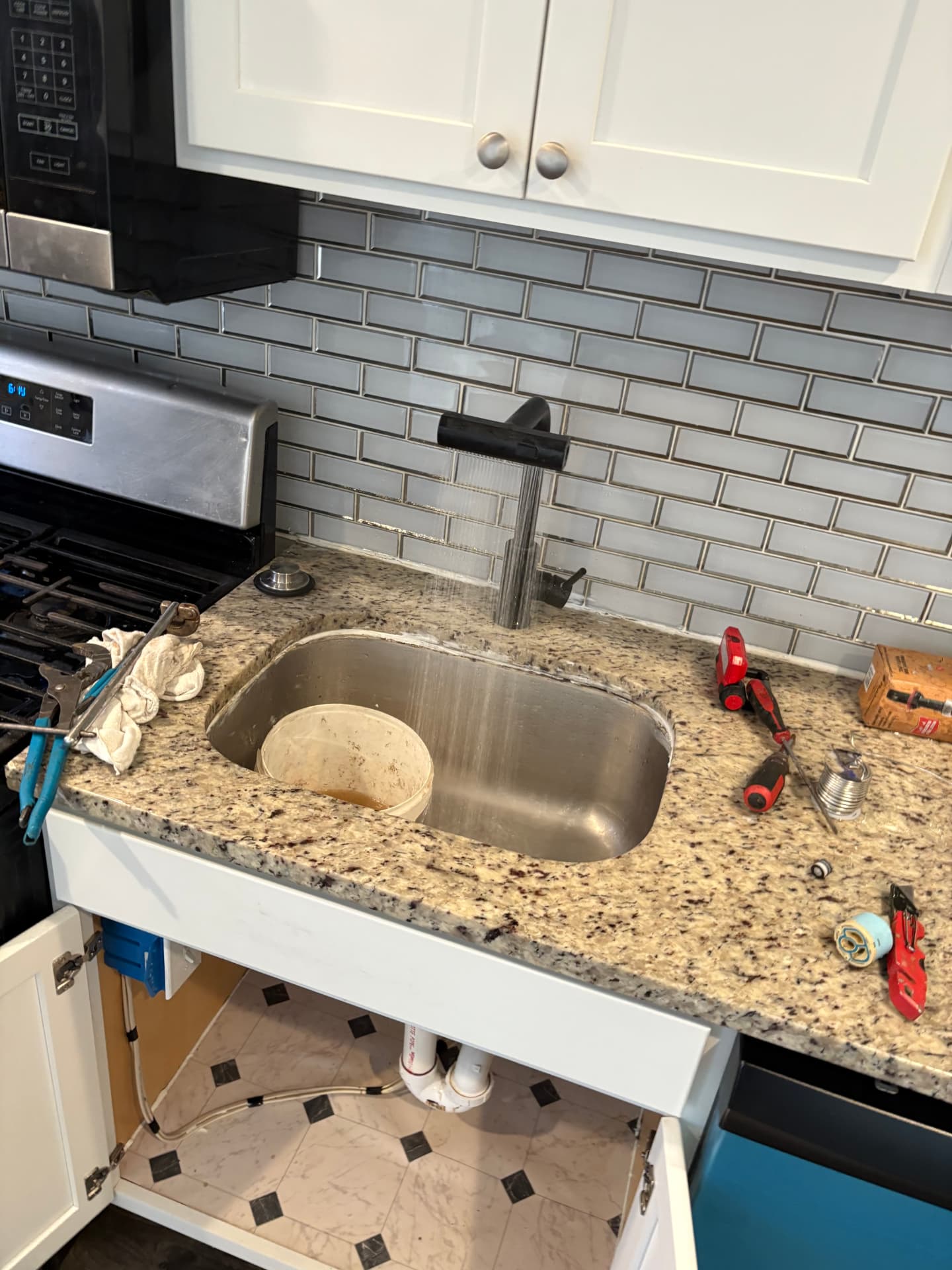 New black kitchen faucet running water into a stainless steel sink in Baltimore, MD — ProStream Plumbing