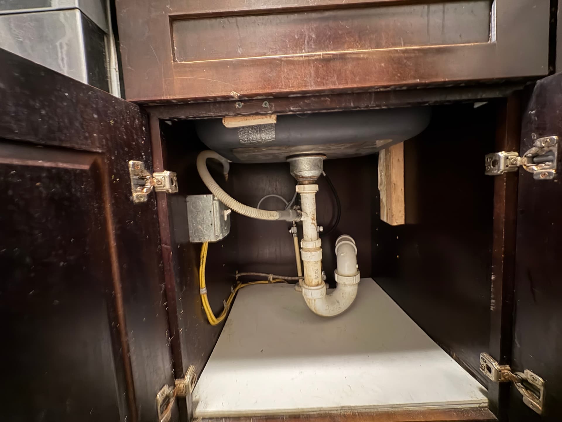 New PVC P-trap and garbage disposal drain connection under a kitchen sink in Baltimore, MD — ProStream Plumbing