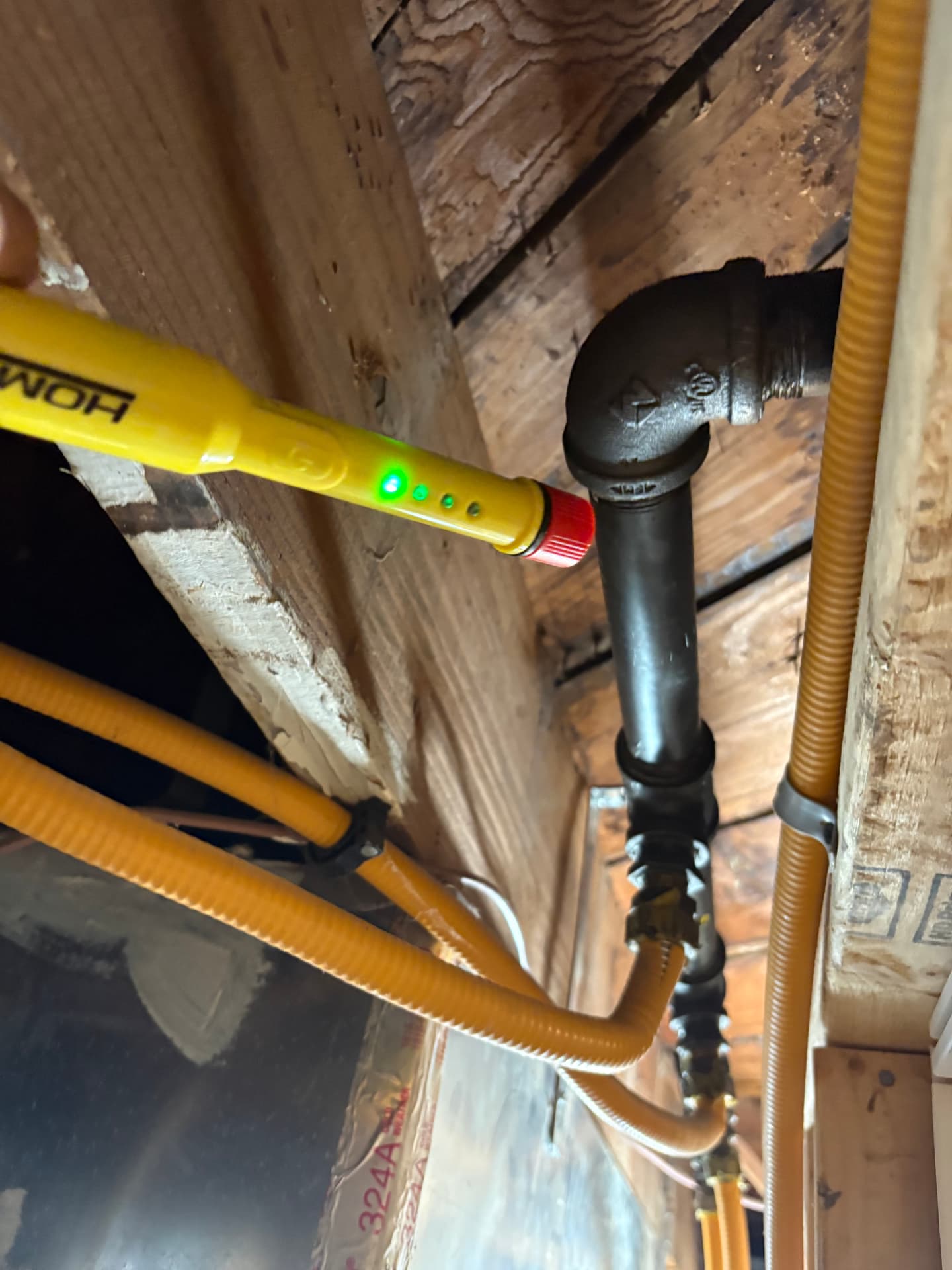 Gas leak detector checking a joint on an overhead gas line near CSST piping in Baltimore, MD — ProStream Plumbing