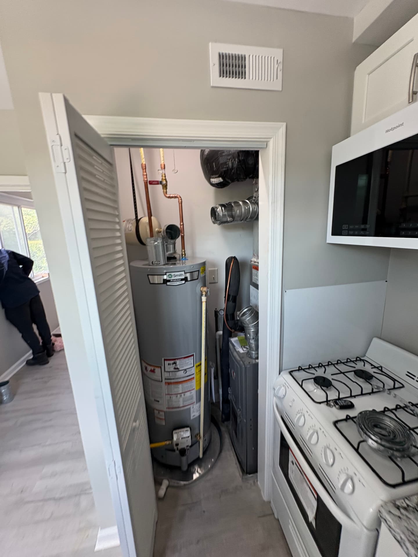 Water heater replacement in a laundry closet next to a furnace in Severna Park, MD — ProStream Plumbing