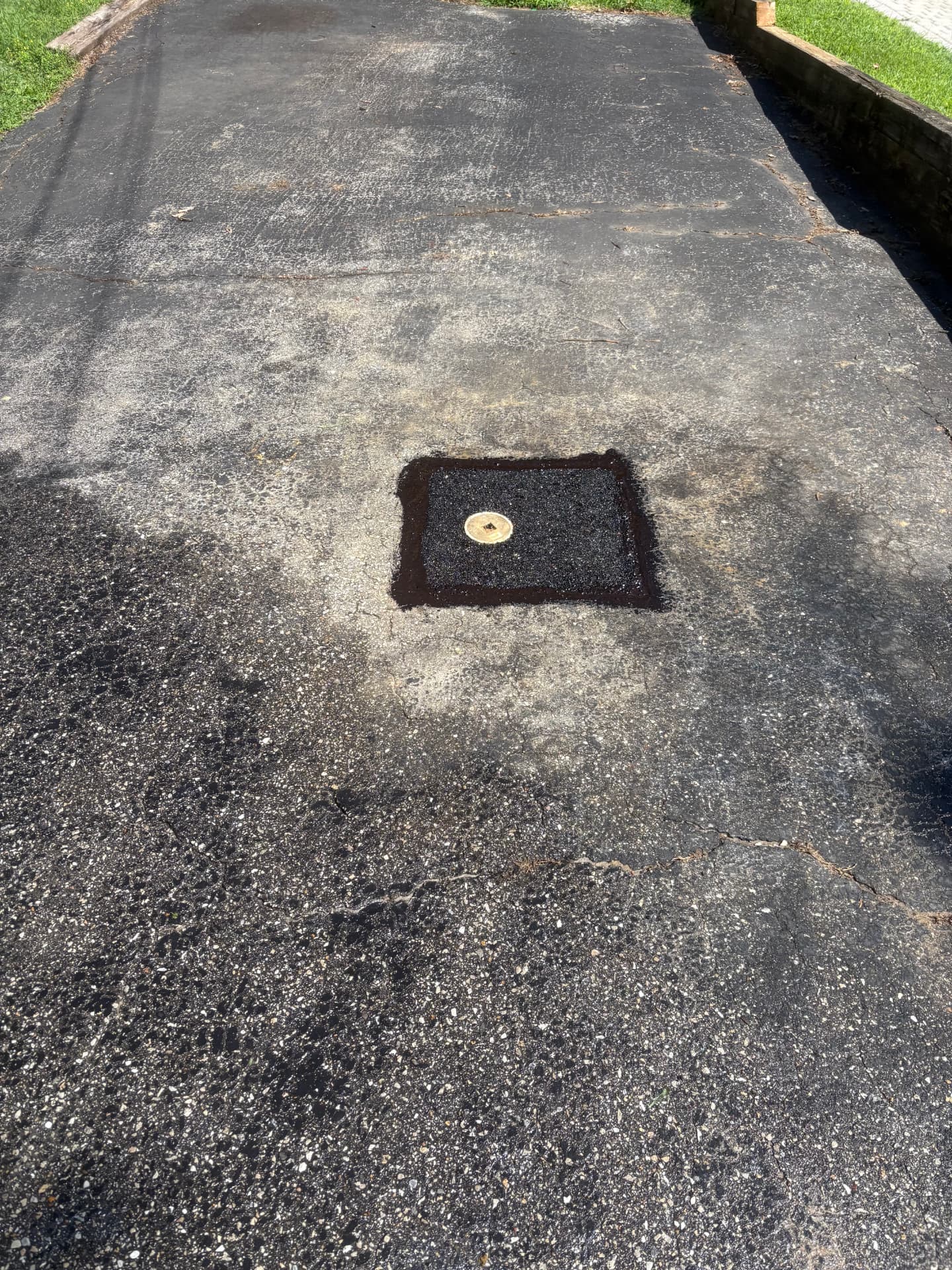 Finished sewer cleanout patched flush in an asphalt driveway in Baltimore, MD — ProStream Plumbing