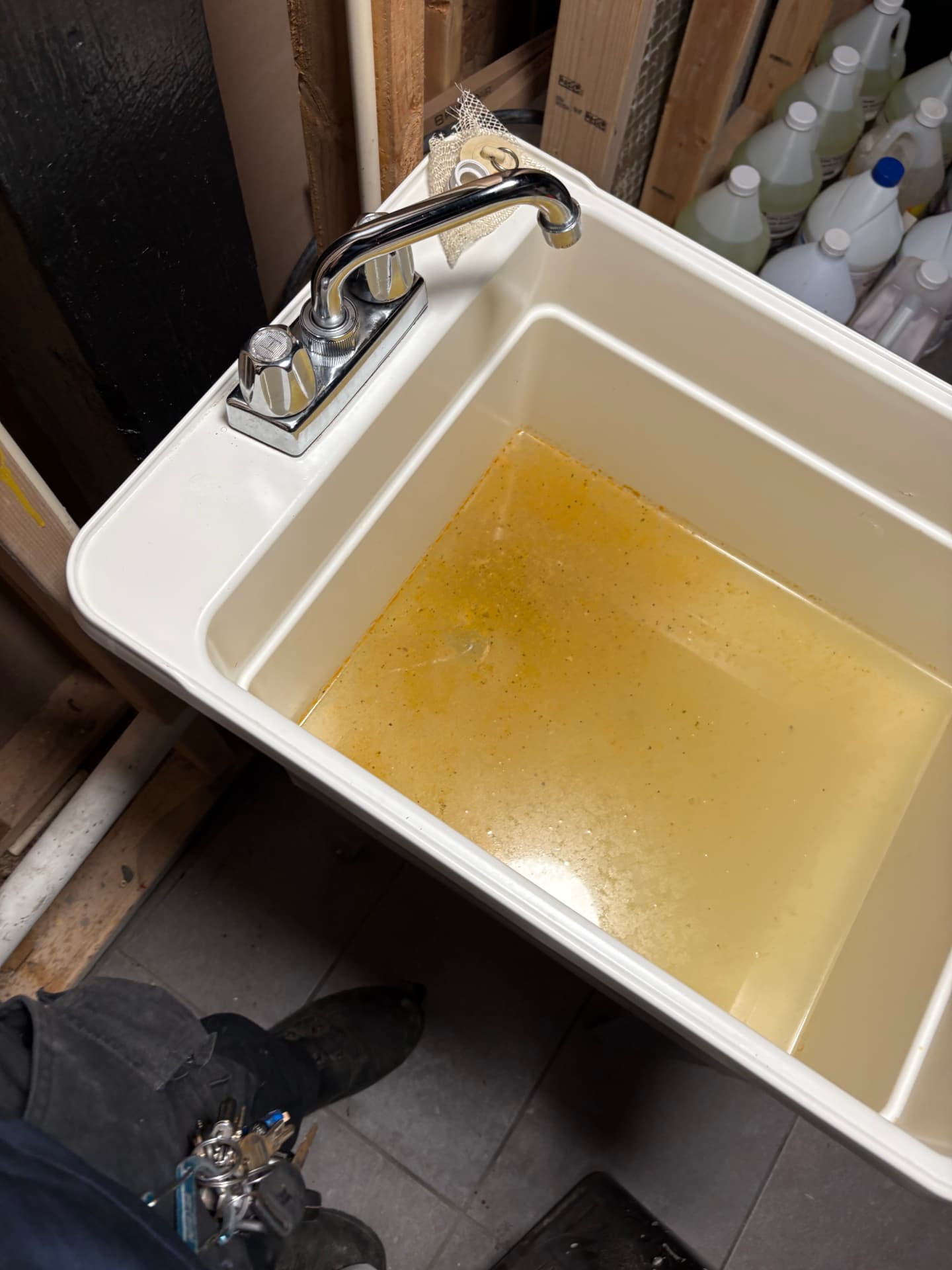 Utility sink filled with standing discolored water from a blocked drain in Baltimore, MD — ProStream Plumbing