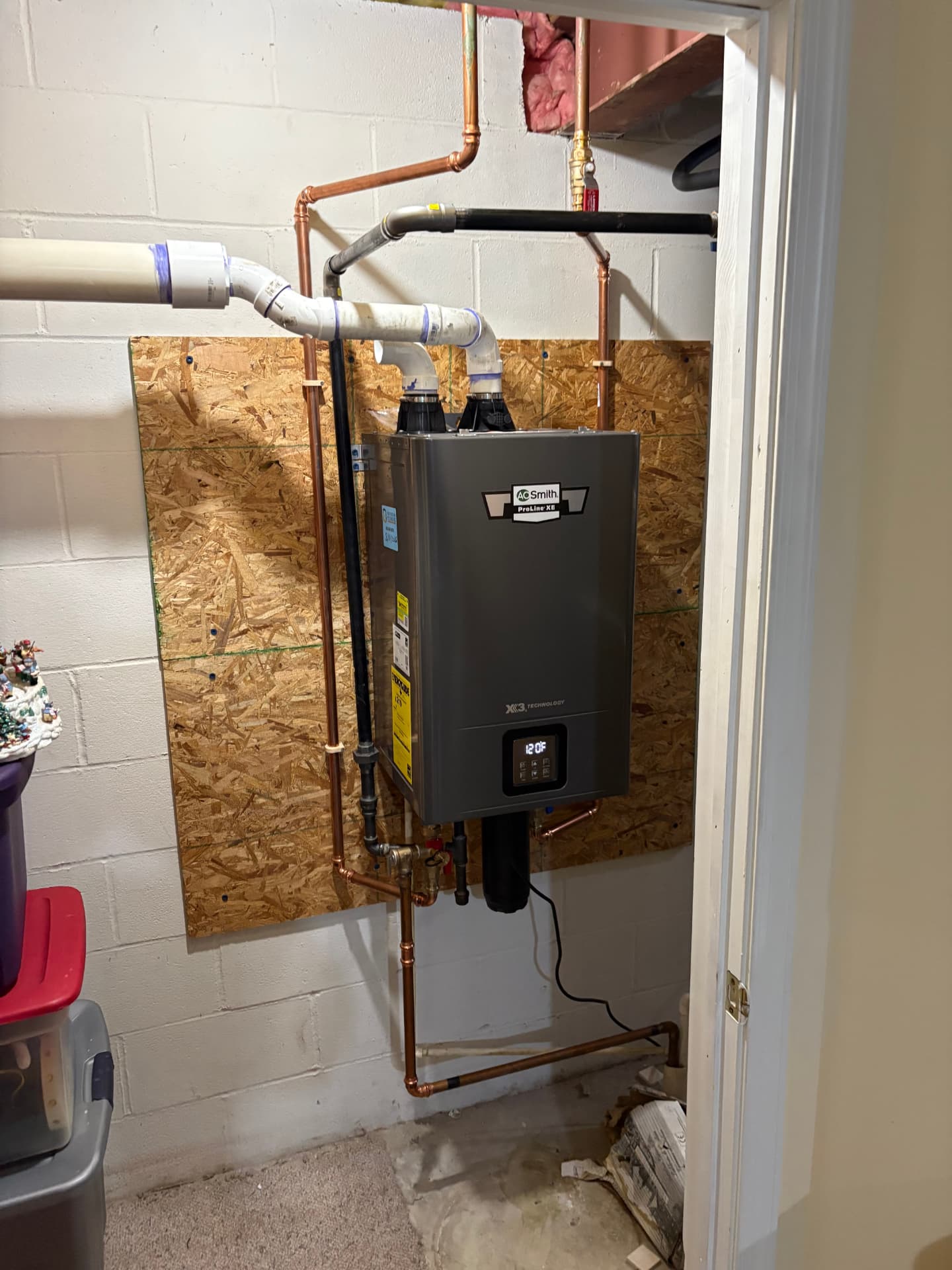 Wall-mounted A.O. Smith tankless water heater installed in a mechanical room in Baltimore, MD — ProStream Plumbing