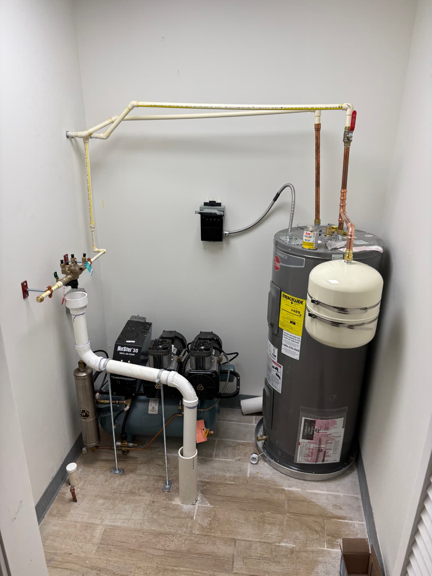 Commercial mechanical room with water heater, backflow preventer and compressor system in Baltimore, MD — ProStream Plumbing